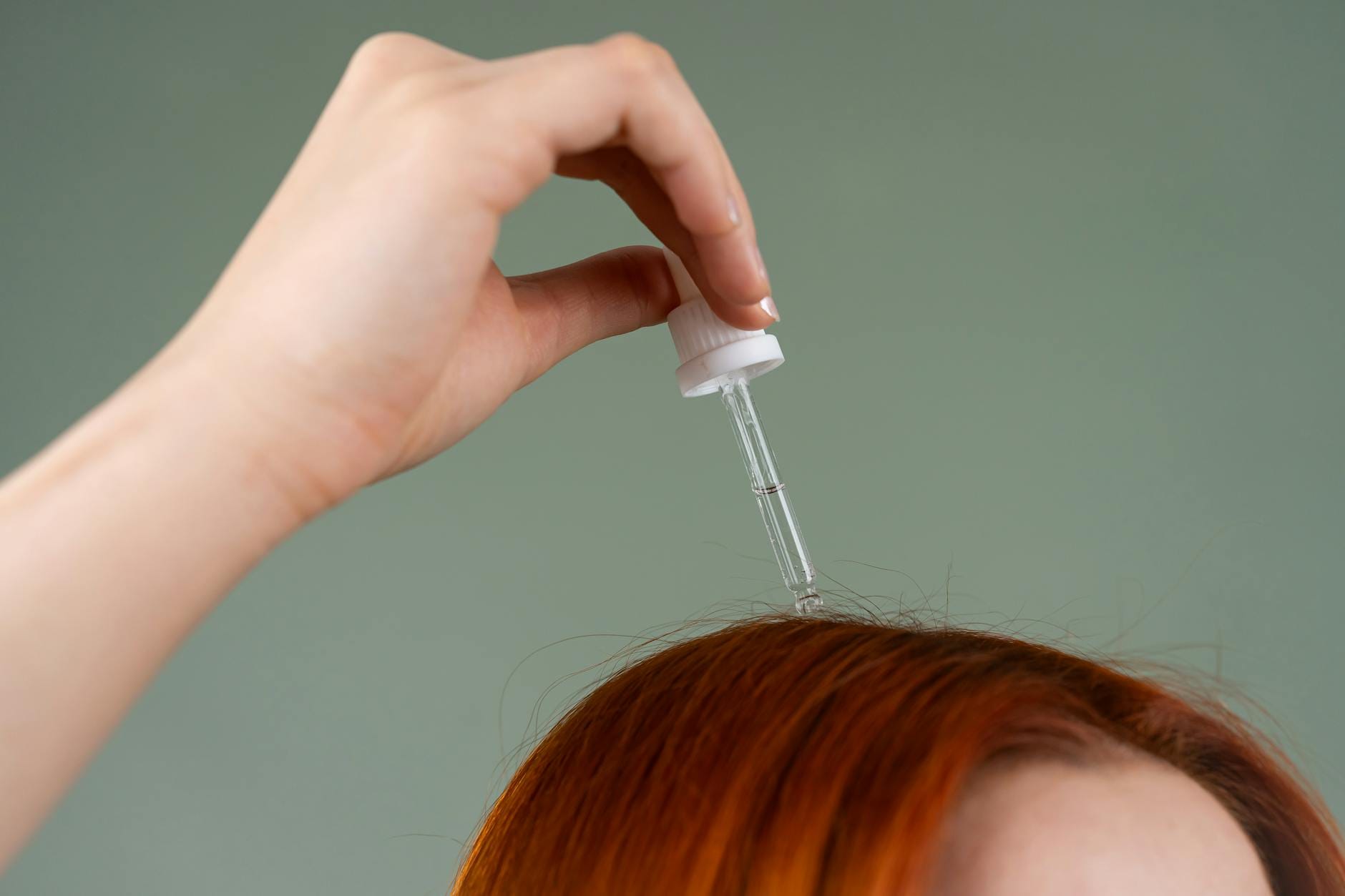 Aplikacja serum na rude włosy pipetą z bliska