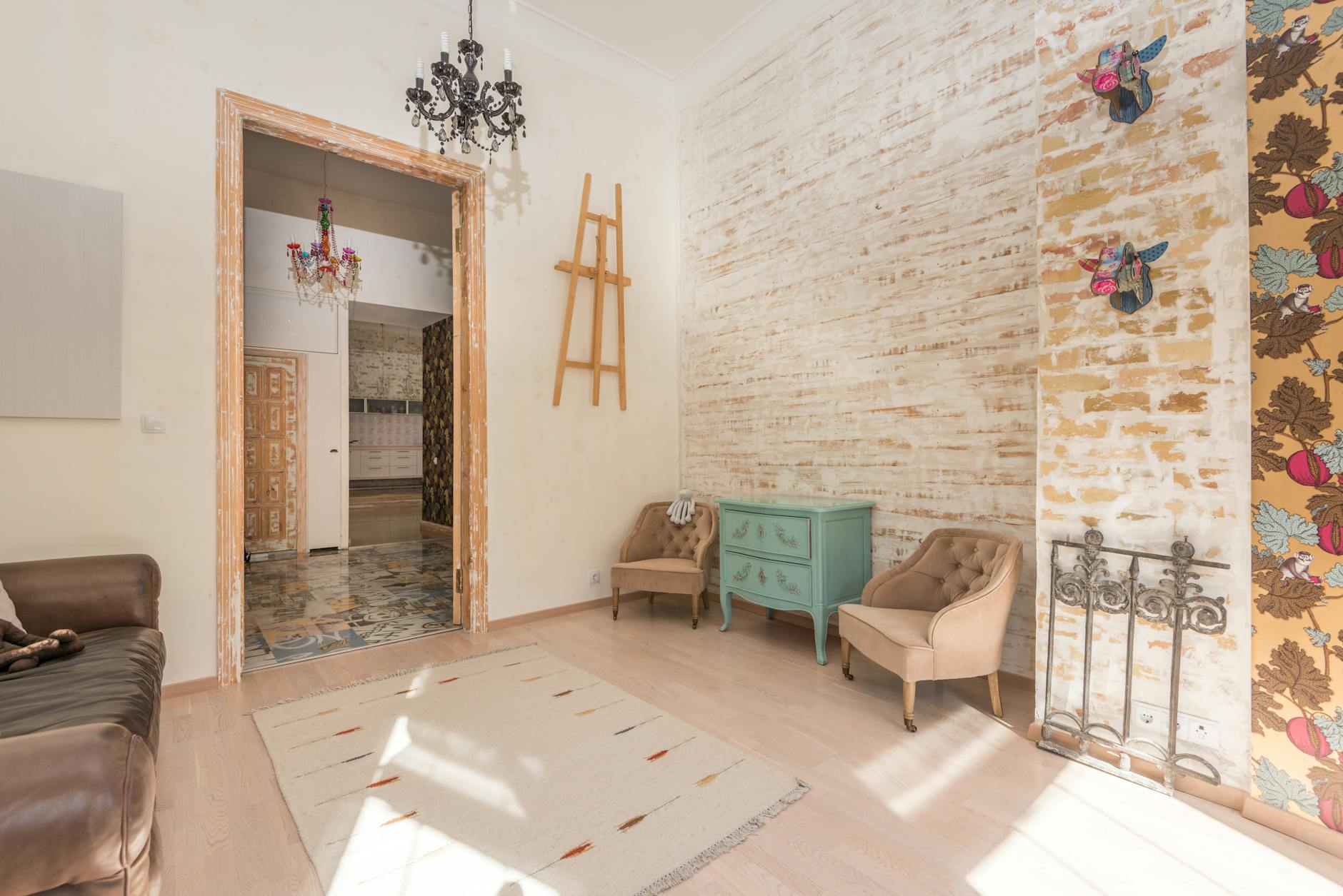 Kolorowy salon w stylu vintage z ceglaną ścianą i ozdobnymi żyrandolami